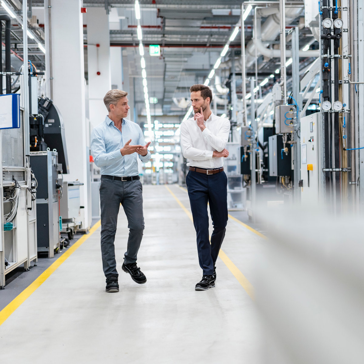 Two businessmen talking in a modern factory